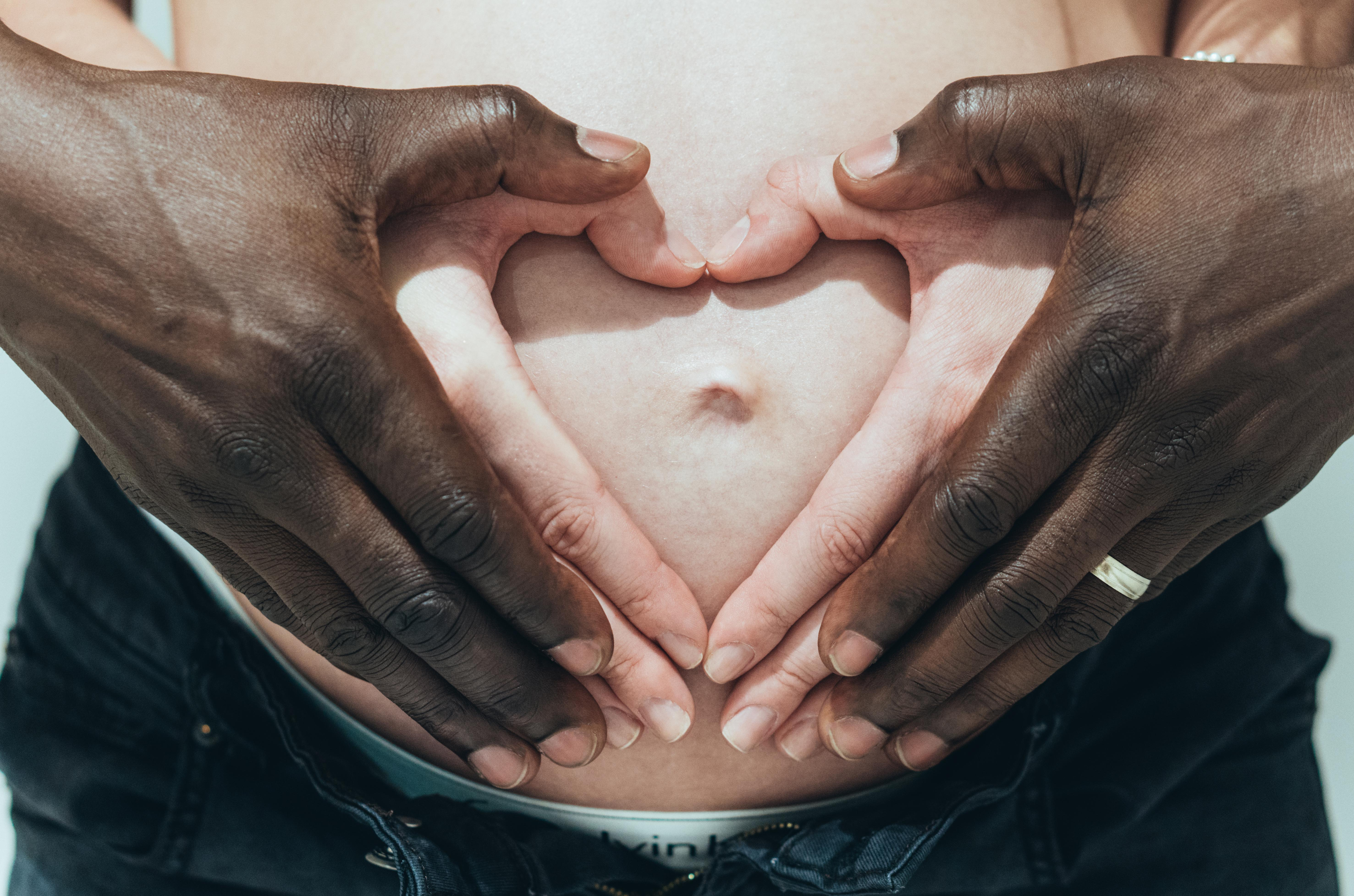 Mixed Race Pregnant Couple Holding Belly