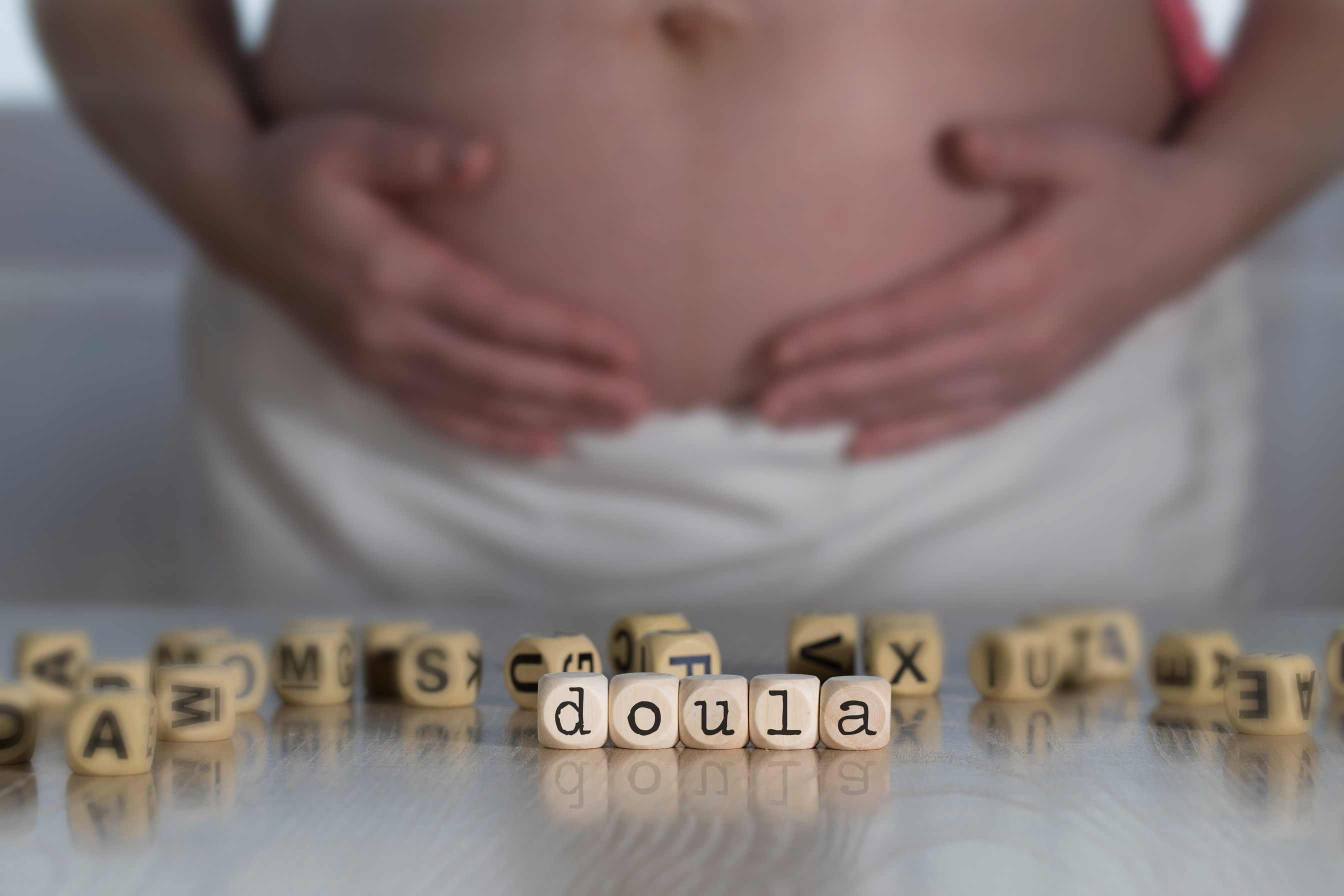Word DOULA composed of wooden letters.